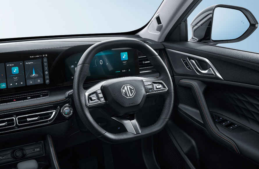 Interior view of MG vehicle showing black leather-wrapped steering wheel with MG logo, digital instrument cluster, touchscreen infotainment system, and modern dashboard design with silver accent trim