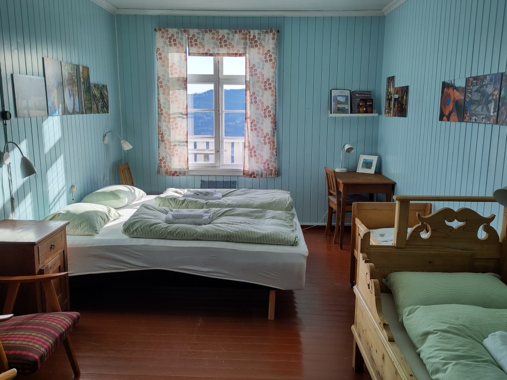 Nr. 2: Skogrommet (familierommet) med tema fra skogen. Her kan du lære mer om all den spennende skogskulturen som finnes i Søndre Land. Dette rommet har utsikt mot Randsfjorden. Det kan også brukes som familierom. Her er en ekstraseng (skuvseng)  1,80 m lang og vi kan sette inn en ekstra seng for mindre barn. På bildet er det satt inn en liten seng som kan trekkes ut i lengden i tillegg til skuvsenga. Vi har også seng med grind for mindre barn..