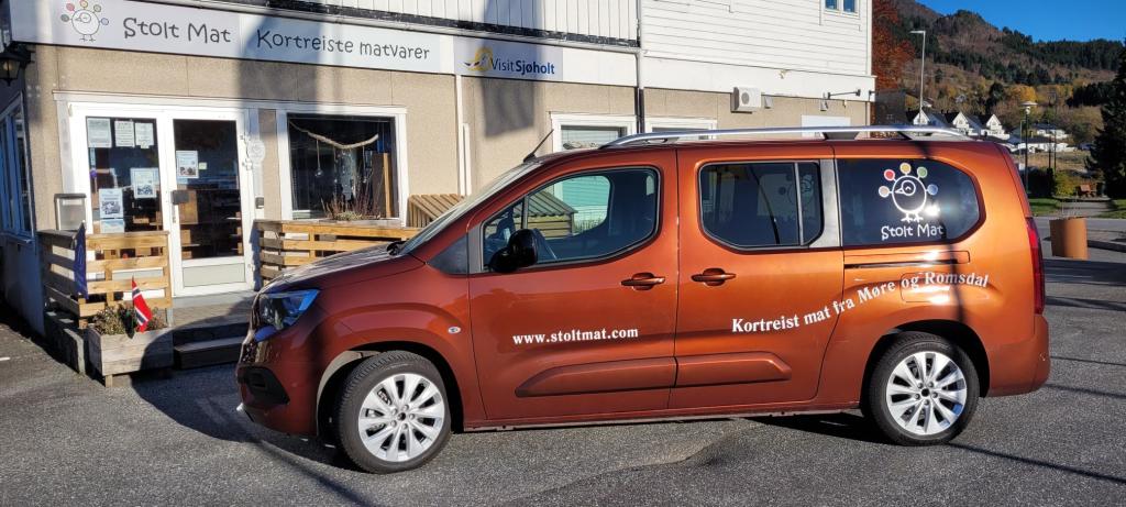 Stolt Mat sin elektriske bil, med logo.