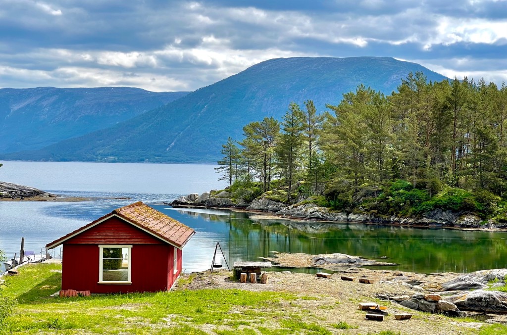 Naustet og brygga i sjøkanten. Stort grøntområde med grill/bålplasser.