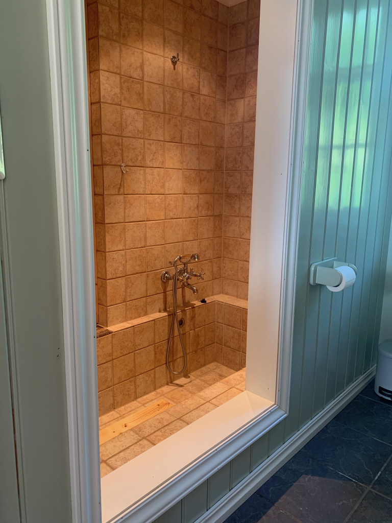 Badet i Bryggerhuset har inngang til eget dusjrom som også fungerer som et stort og flott badekar