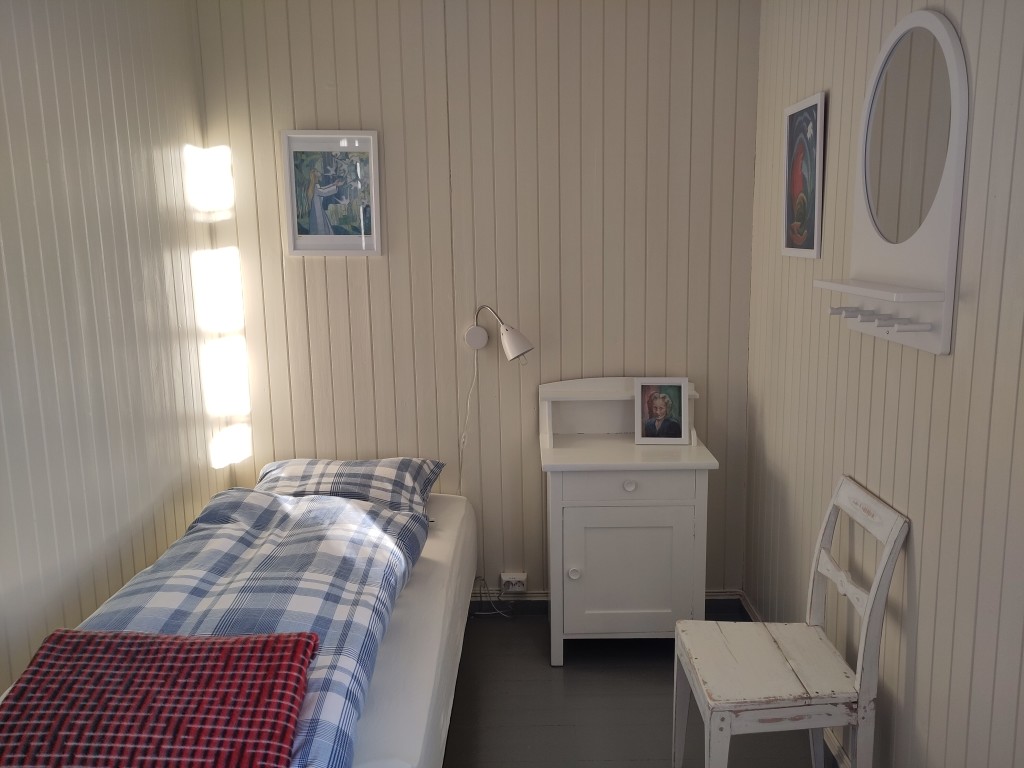 Rom nr. 11: Enkeltrom med utsikt mor hagen. Med bilder malt av kunsteneren Calla Skrøvseth som bodde på dette rommet i 1950 åra mens hun hvilte og malte bilder med motiv fra gården og utsikten.