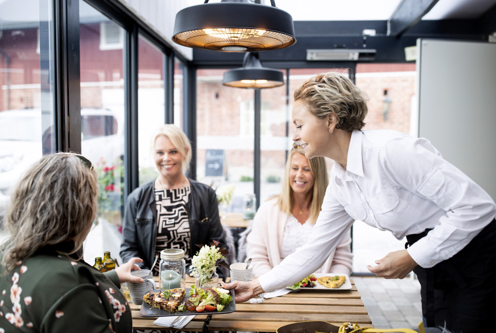 Linda serverer gjester lunch i den populære gårdskafeen vår.