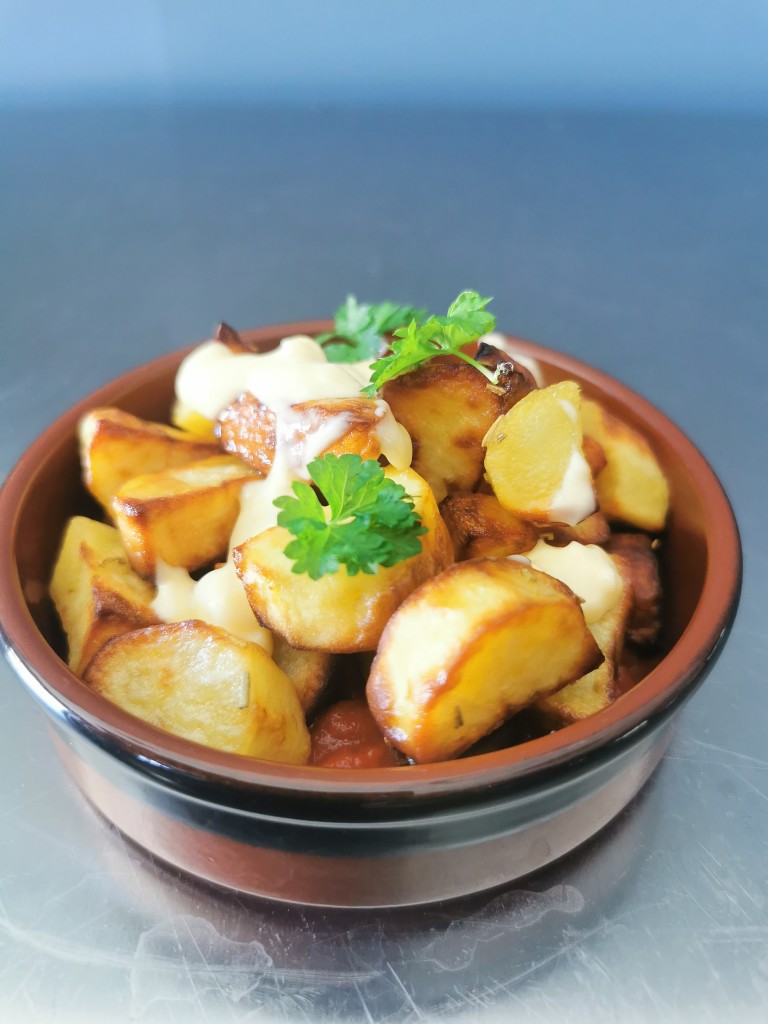 Potatas bravas med cherrysmak og norske poteter, toppet med hvitløksdressing.