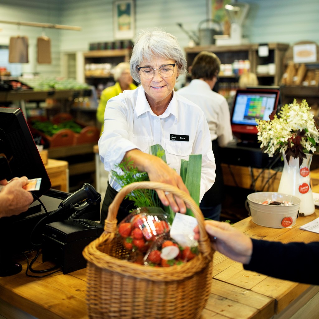 Grete ekspederer kunder i gårdsmarkedet