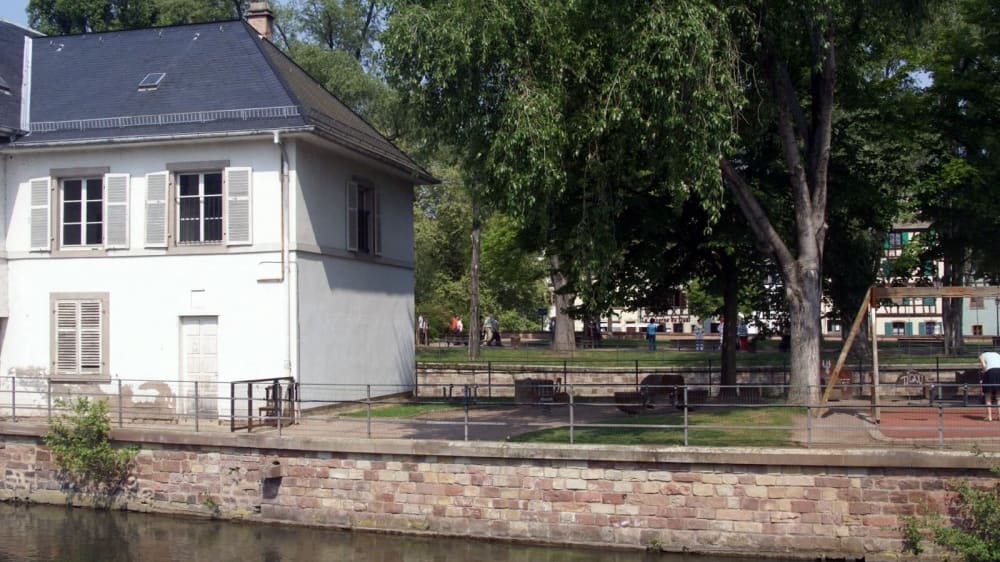 סקוָואר דֶה מוּלאן, פארק מוצל עם ספסלים ומגרש משחקים קטן