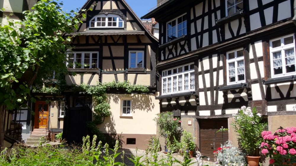 בתים עתיקים עם אדניות פרחים ססגוניות לאורכה של הסמטה הצרה והיפהפייה אֶנגֶלגאסֶה