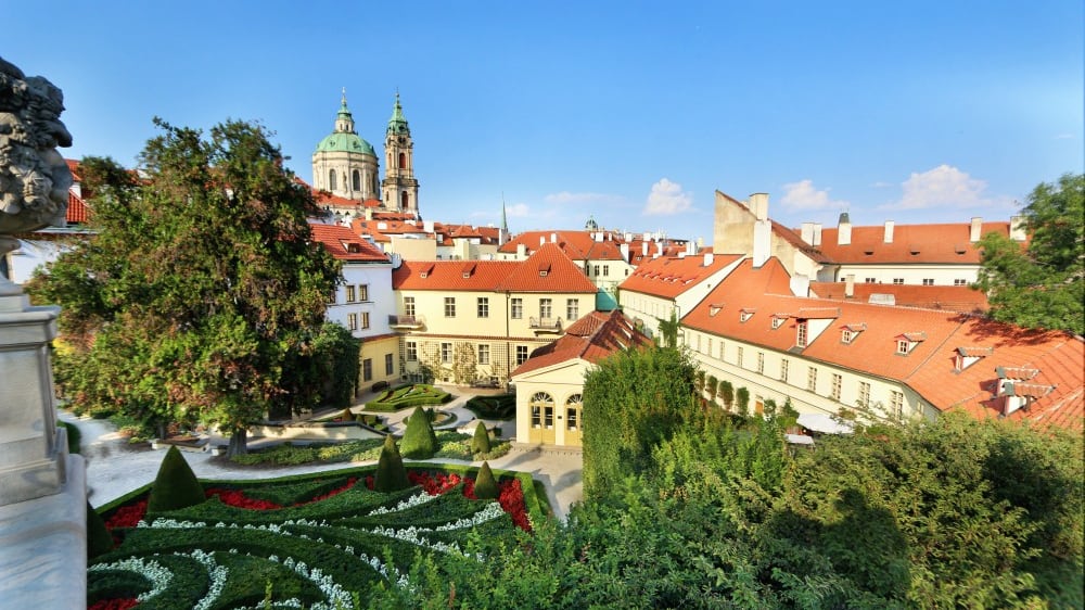 גן‭ ‬וֶרטבּוֹב הגיאומטרי על רקע כנסיית ניקולאס הקדוש וגגותיה האדומים של מָאלָה סְטְרָאנָה