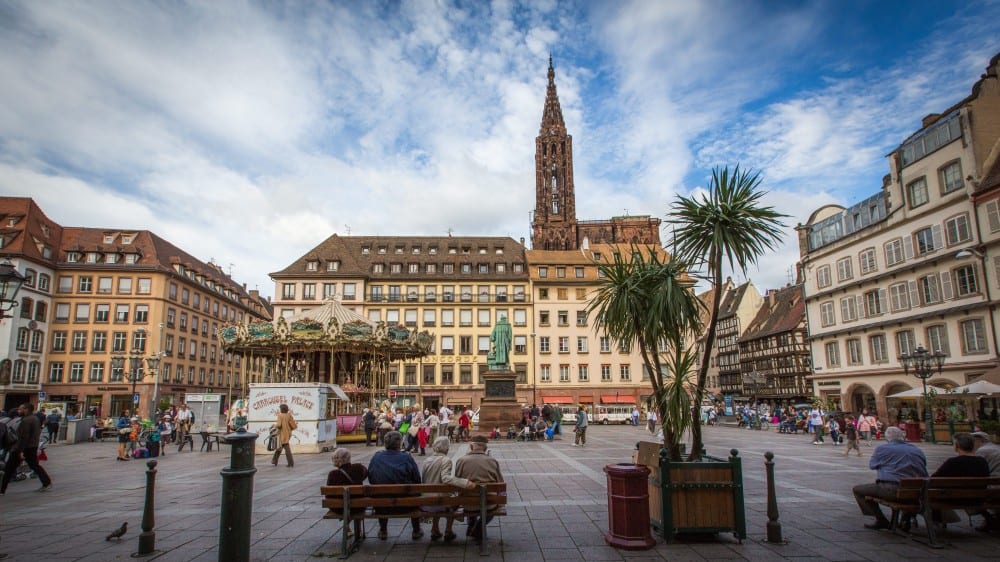 פסלו של גוּטֶנבֶּרג במרכז כיכר גוּטֶנבֶּרג וברקע הקתדרלה של שטראסבּוּרג