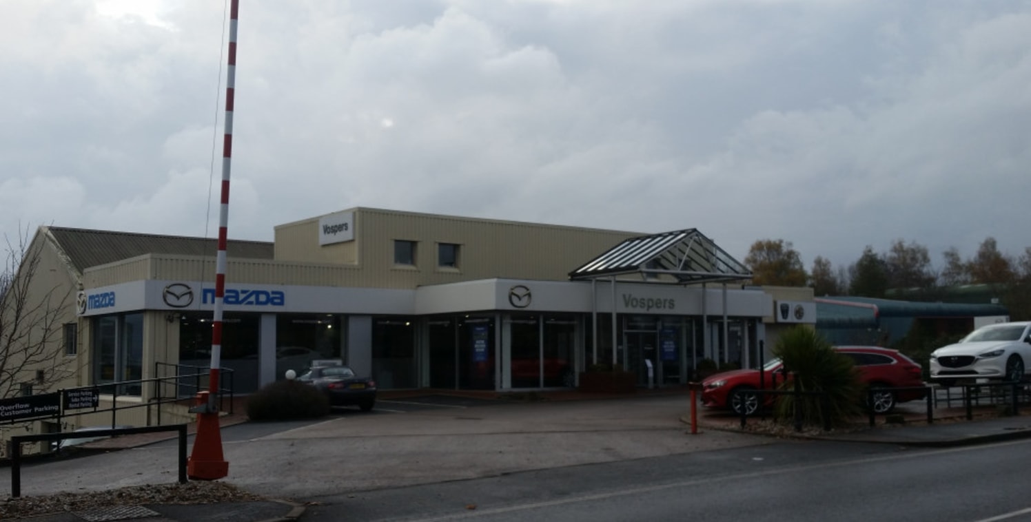 The property is situated in a high profile location on the A3015 which links J29 of the M5 to Exeter city centre. The property comprises showroom and offices at ground floor, offices/storage above and workshops at lower level with parts storage at an...