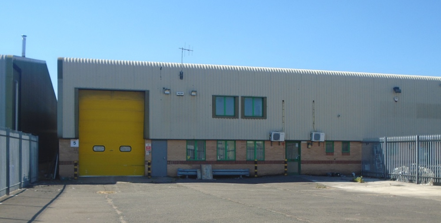 The property comprises a semi-detached steel portal frame industrial unit with facing brick lower elevations and profile sheeting to the upper aspect, which is rolled at the eaves. The building occupies a self-contained site which has palisade perime...