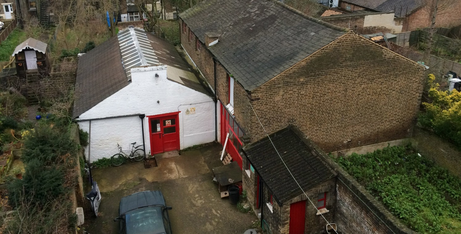 The property is accessed through a drive and comprises light industrial workshop with office and storage. Divided between two large buildings, the property also benefits from a private yard. 

The building is located in a backlands site at the rear o...