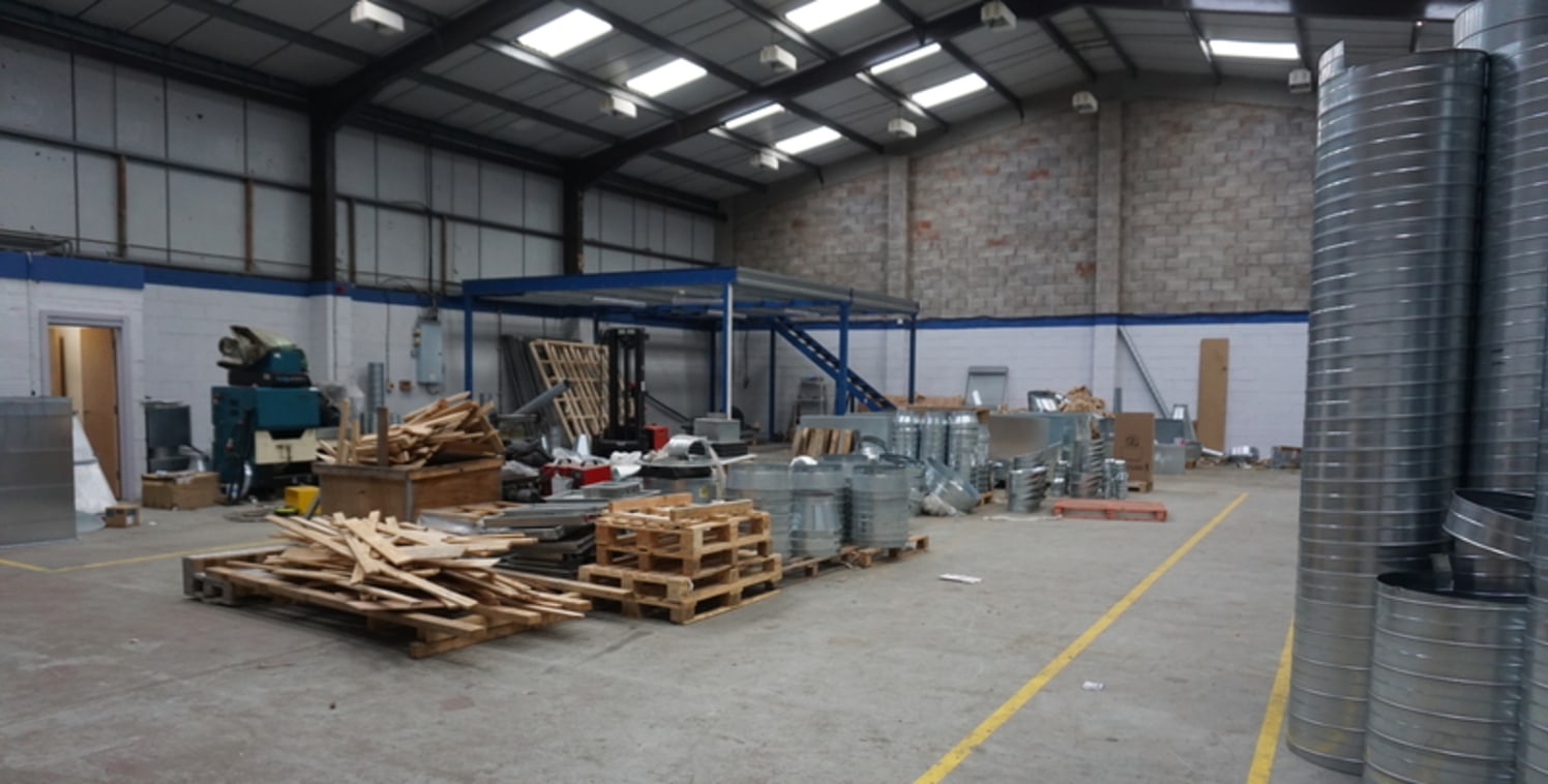 The property comprises a single storey mid-terrace warehouse, constructed around a steel portal frame with a concrete floor and part block/part clad elevations, surmounted by a profile metal sheet pitched roof incorporating lights. The warehouse is l...