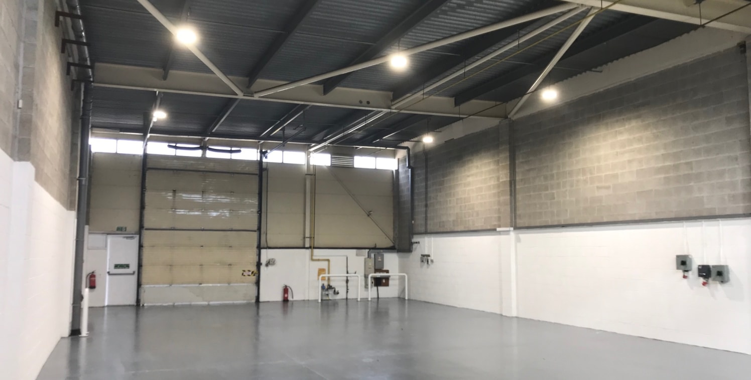 A modern single storey warehouse unit benefitting from the following:\n\n* 5.14m eaves\n* high quality offices\n* large shared yard with separate car parking\n* heating and lighting to both the offices and warehouse space\n* level access loading via...