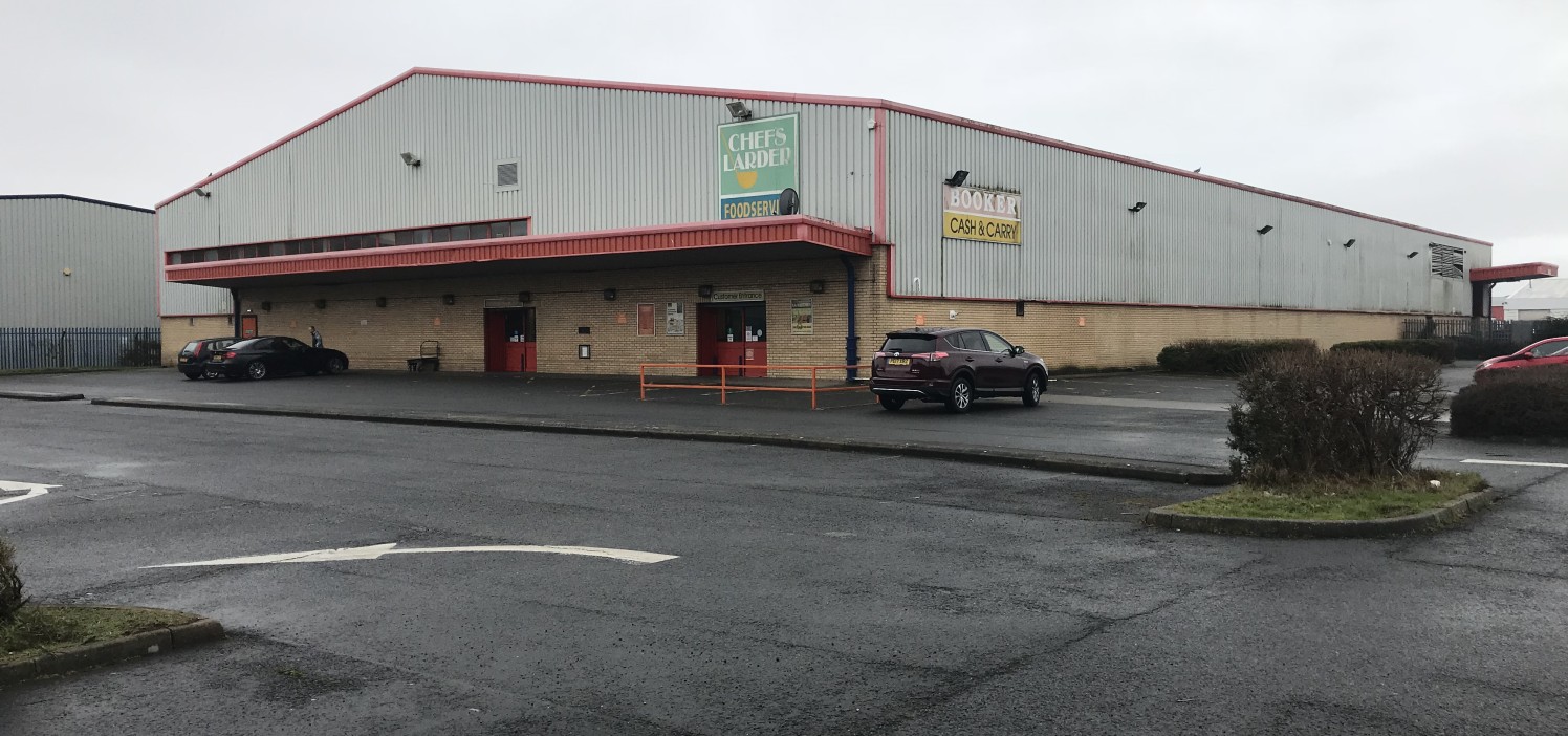 The property comprises a detached, steel portal frame warehouse property with a minimum eaves height of approximately 6.7 metres and part brick elevations and part profile cladding sheeting. There is a separate customer access covered by a canopy wit...