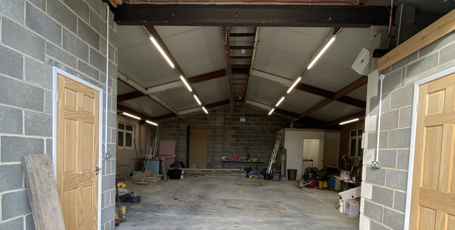 The property compromises a steel portal frame semidetached industrial unit with a metal profile sheet roof, concrete floor and part brick/ part block walls. The unit benefits from LED lighting, an electric roller shutter door to the front elevation a...