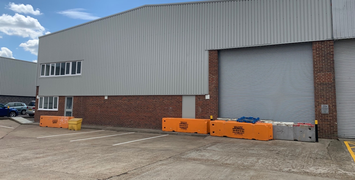 The unit is of steel portal frame construction with brick elevation and steel profile cladding. The unit benefits from a roller shutter door and loading area with first floor offices and yard / car parking to the front.