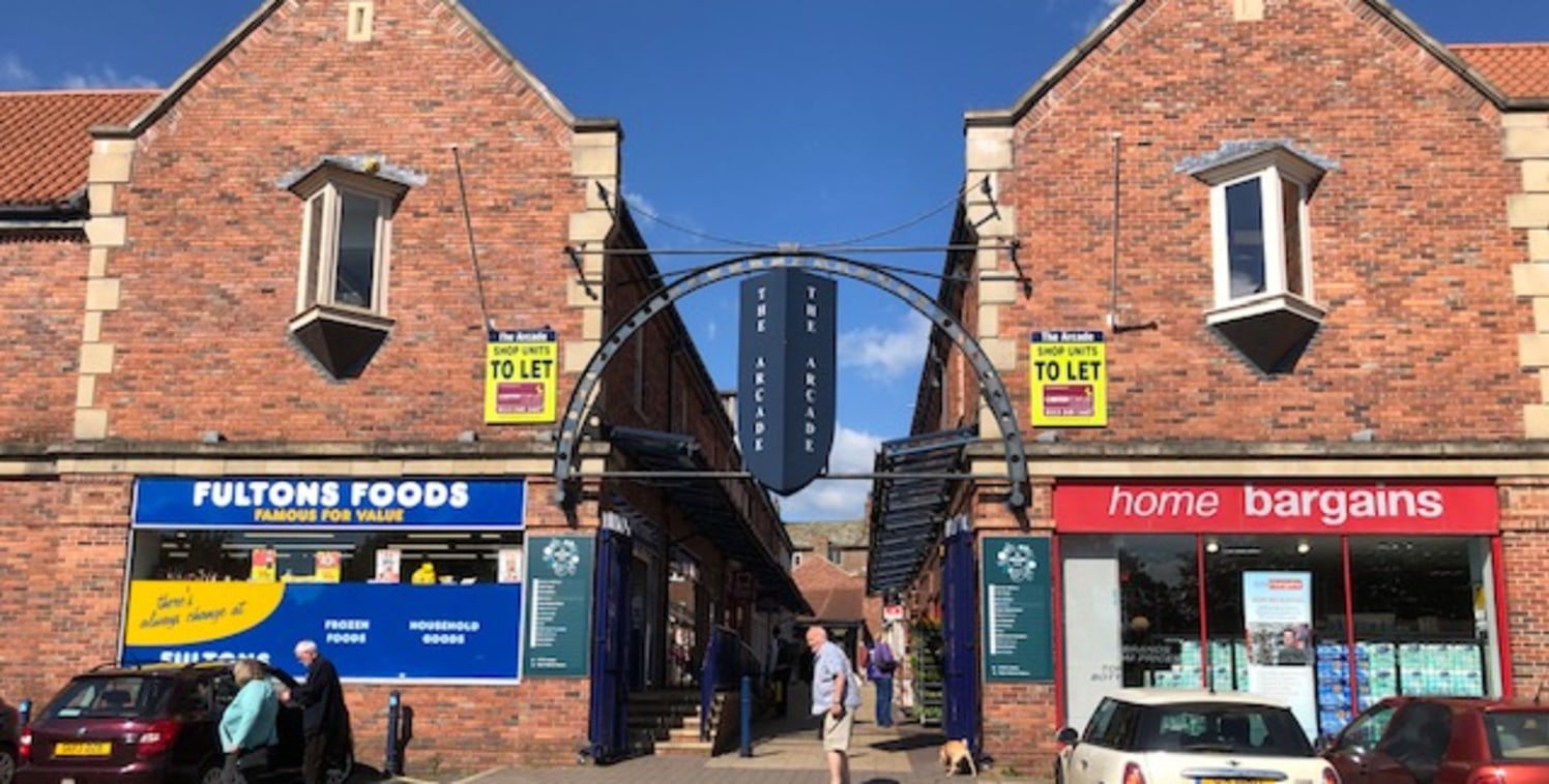 The unit is located opposite Home Bargains within The Arcade and is arranged over ground floor level comprising an open plan sales area with rear w/c.