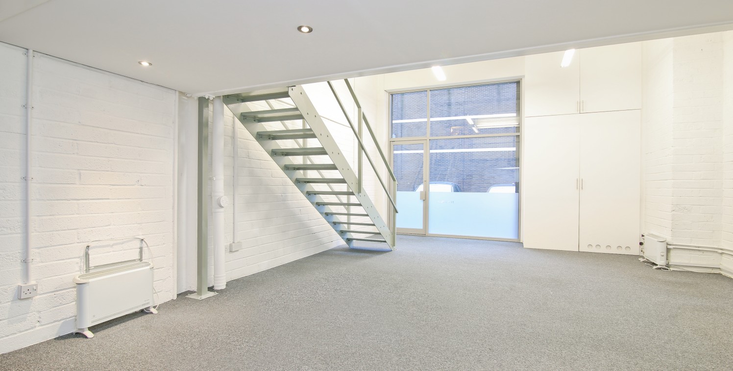 This stylish office is on two levels benefiting from floor to ceiling windows offering lots of natural light to both ground floor and mezzanine level. The unit is carpeted, with painted brick walls and an exposed concrete ceiling. There is a kitchene...