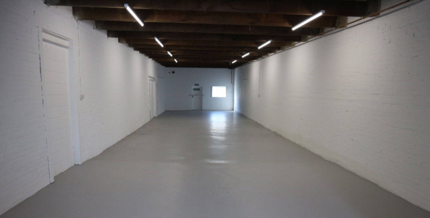 The premises comprise a traditional open plan workshop / storage unit accessed via a large electric loading door.