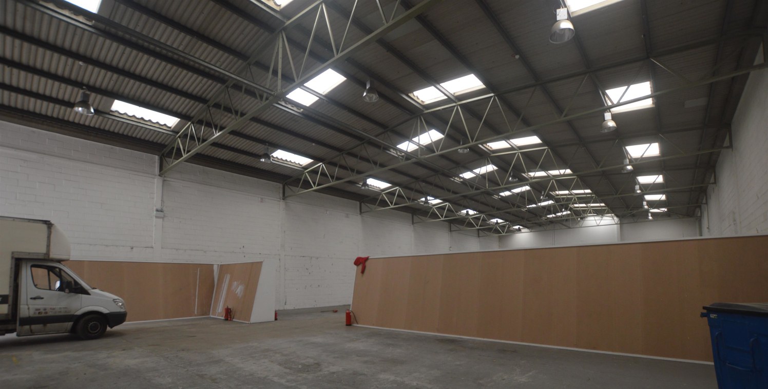 The unit is of steel portal frame construction with brick elevation and steel profile cladding. The unit benefits from a roller shutter door and loading area with first floor offices and yard / car parking to the front.