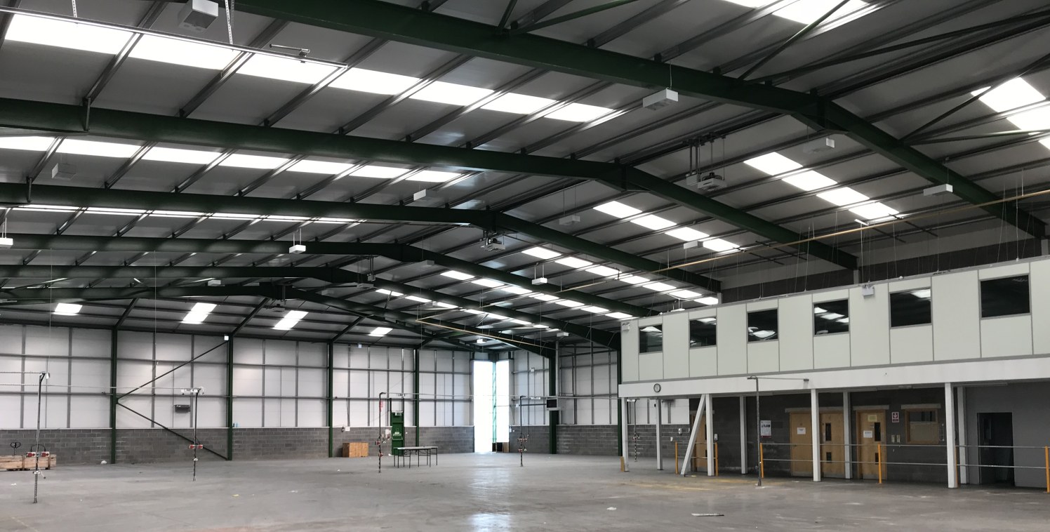 The property comprises a detached high specification steel portal frame industrial unit under a pitched insulated profile metal roof, with insulated metal profile cladding over brick and block walls. Internally the warehouse benefits from concrete fl...