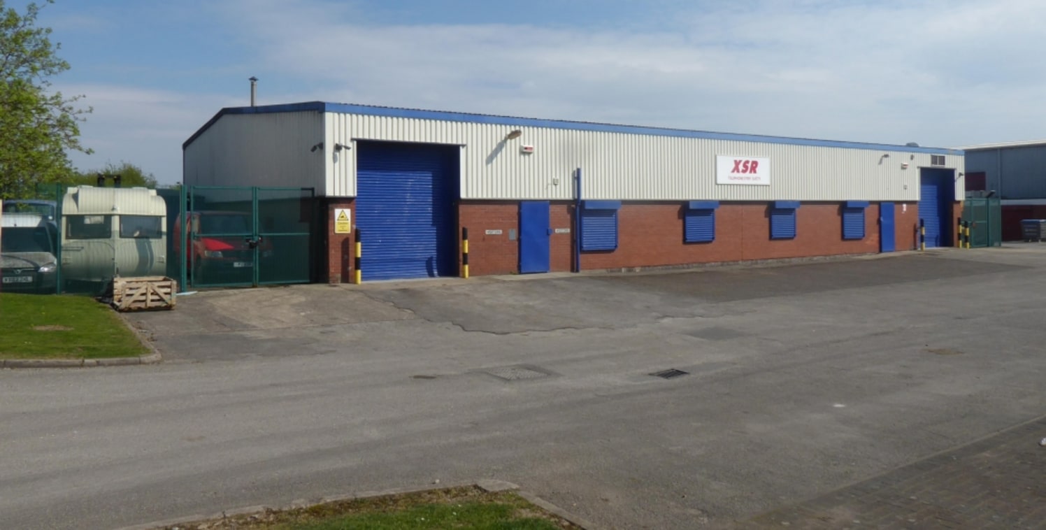 Detached steel portal frame industrial building with parking and secure yards. Currently fitted as vehicle workshop.