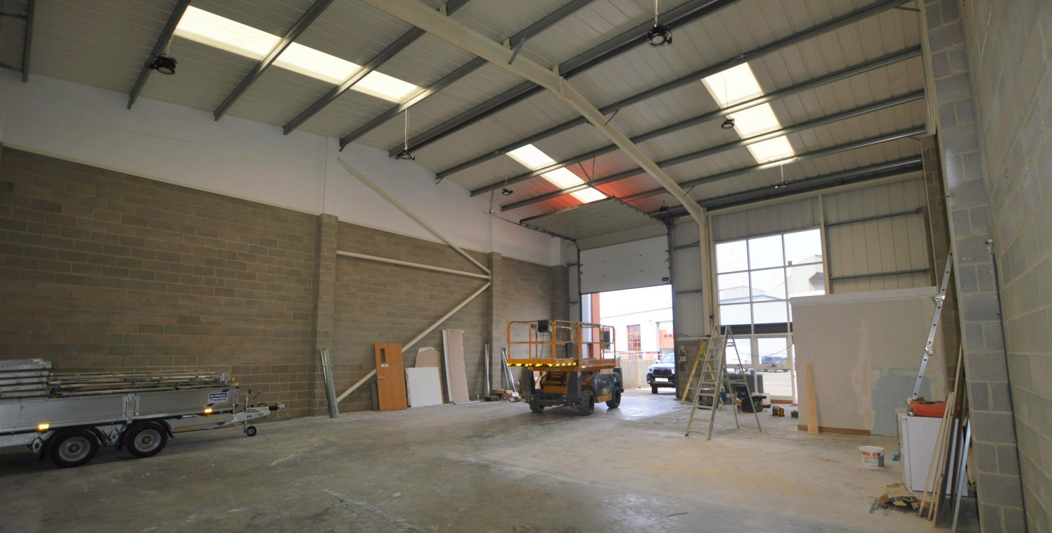 The premises comprise a mid-terrace single storey steel framed building with brick profile steel cladding to the roof and brick and partial steel profile cladding to the front and side elevations.

In addition, there is a generous car parking / yard...