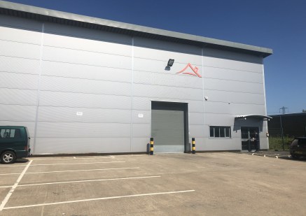 The property is an end terraced light industrial unit of steel portal frame construction with brick and profile sheet clad elevations and mono pitched roofs of insulated steel cladding and roof panels.

The unit benefits from electric roller shutter...