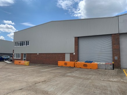 The unit is of steel portal frame construction with brick elevation and steel profile cladding. The unit benefits from a roller shutter door and loading area with first floor offices and yard / car parking to the front.