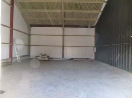 STORAGE BARN / INDUSTRIAL UNIT - EXCELLENT ROAD LINKS TO THE A24 | A concrete portal framed barn with steel cladding under a pitched sheeted roof. Features include steel roller shutter loading door, 3 phase power available, lighting and power sockets...