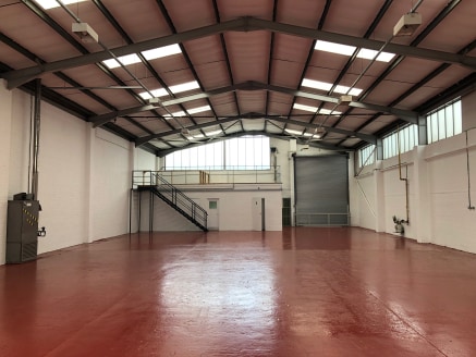 The property comprises a steel portal frame construction with part brick built/part glazed elevations and a pitched corrugated asbestos roof incorporating translucent light panels. Eaves height is approximately 5....