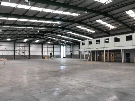The property comprises a detached high specification steel portal frame industrial unit under a pitched insulated profile metal roof, with insulated metal profile cladding over brick and block walls. Internally the warehouse benefits from concrete fl...