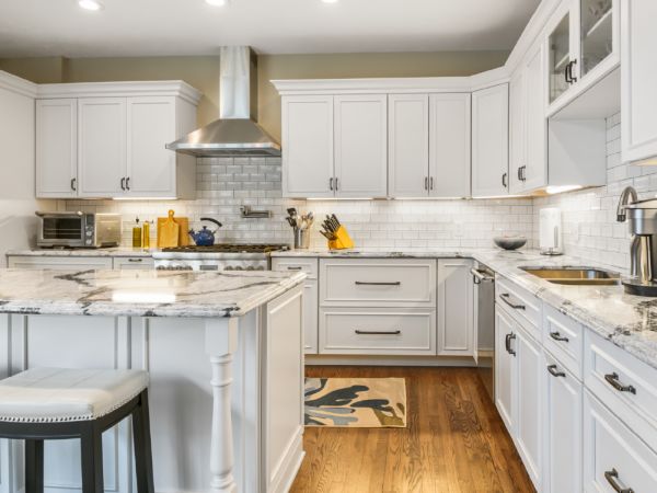 The white cabinets with the white island, and white tile backsplash.