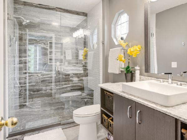 The sophisticated modern bathroom with a walk-in shower with Maverick tile, a floating vanity, and a white toilet.