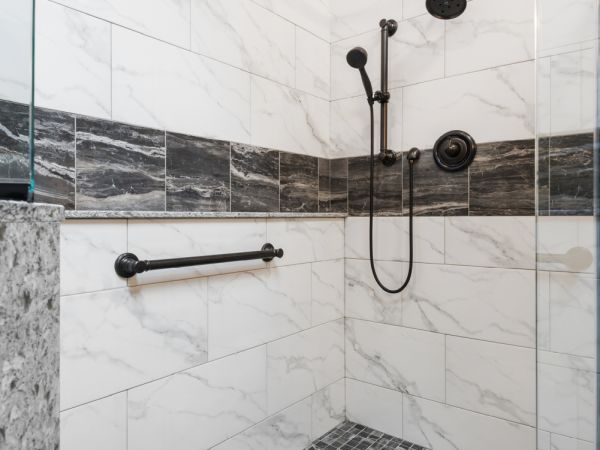 The shower's large veined tile with smaller marbled accent tile.