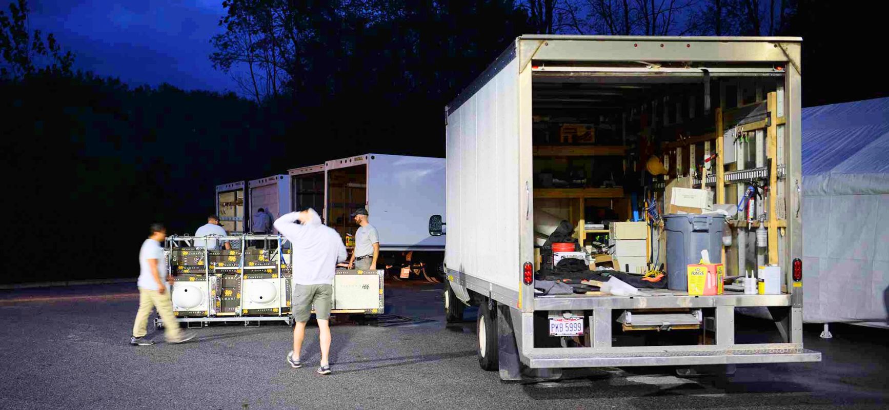 Does your Installation Crew Stay Overnight - Workers by Trucks in Dusk