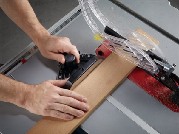 a plank of wood being run through a Bosch router table