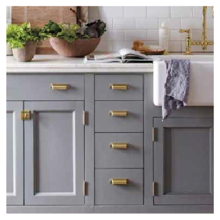 Gold door pulls on blue-grey cupboard doors in a kitchen.