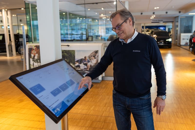 Frank Gjersøe viser hvordan skjermene brukes i butikk