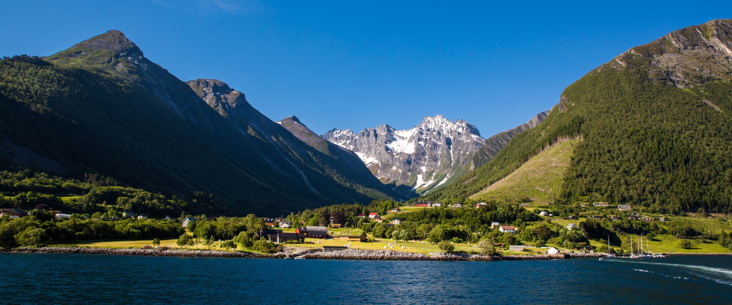 A small hamlet under high mountains in Hjørundfjorden: Photo: AdobeStock