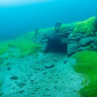 Diving in Lyngstøylvatnet where small farms where submerged. Photo: Adobe Stock