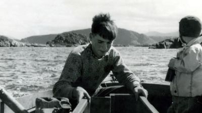 Black and white photo of Per on a boat as a young boy.