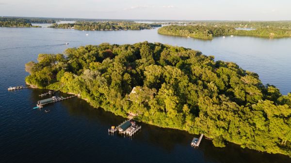 Aerial view of a wooded lake island with docks and calm water in Minnesota