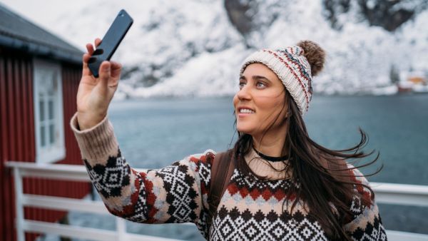 Traveler wearing a knit sweater and hat in cold, windy weather.