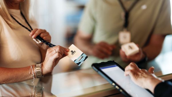 a woman holding her keycard up for payment in a shop