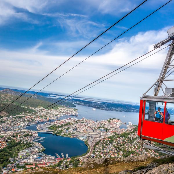 Red cable car on its way up to the 643 meter high mountain Ulriken, with a view over the city of Bergen.