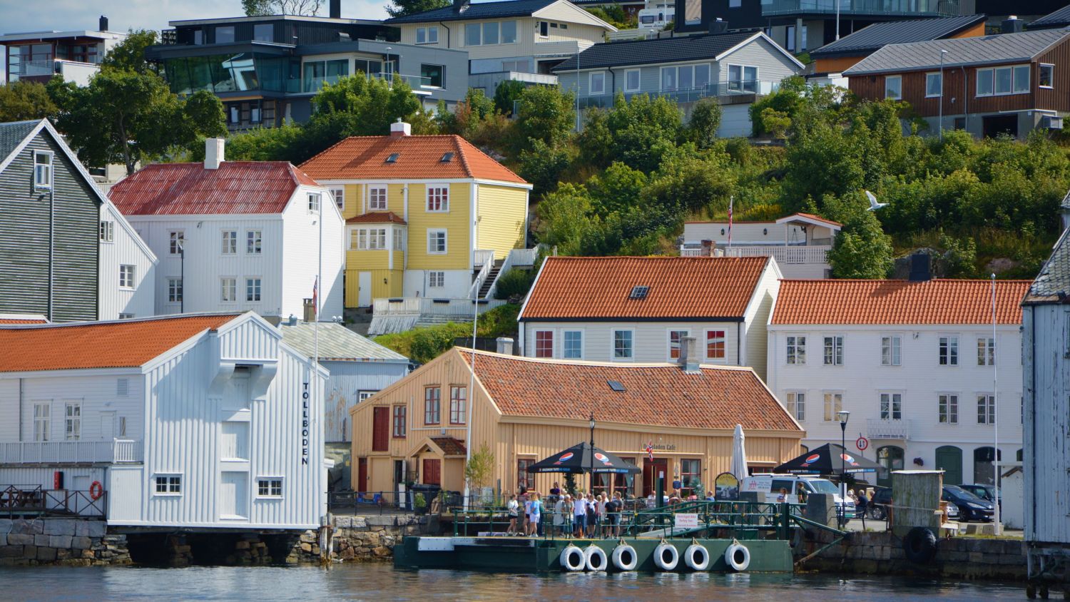 Old, white wooden houses and an outdoor cafe on a sunny summerday in Kristiansund