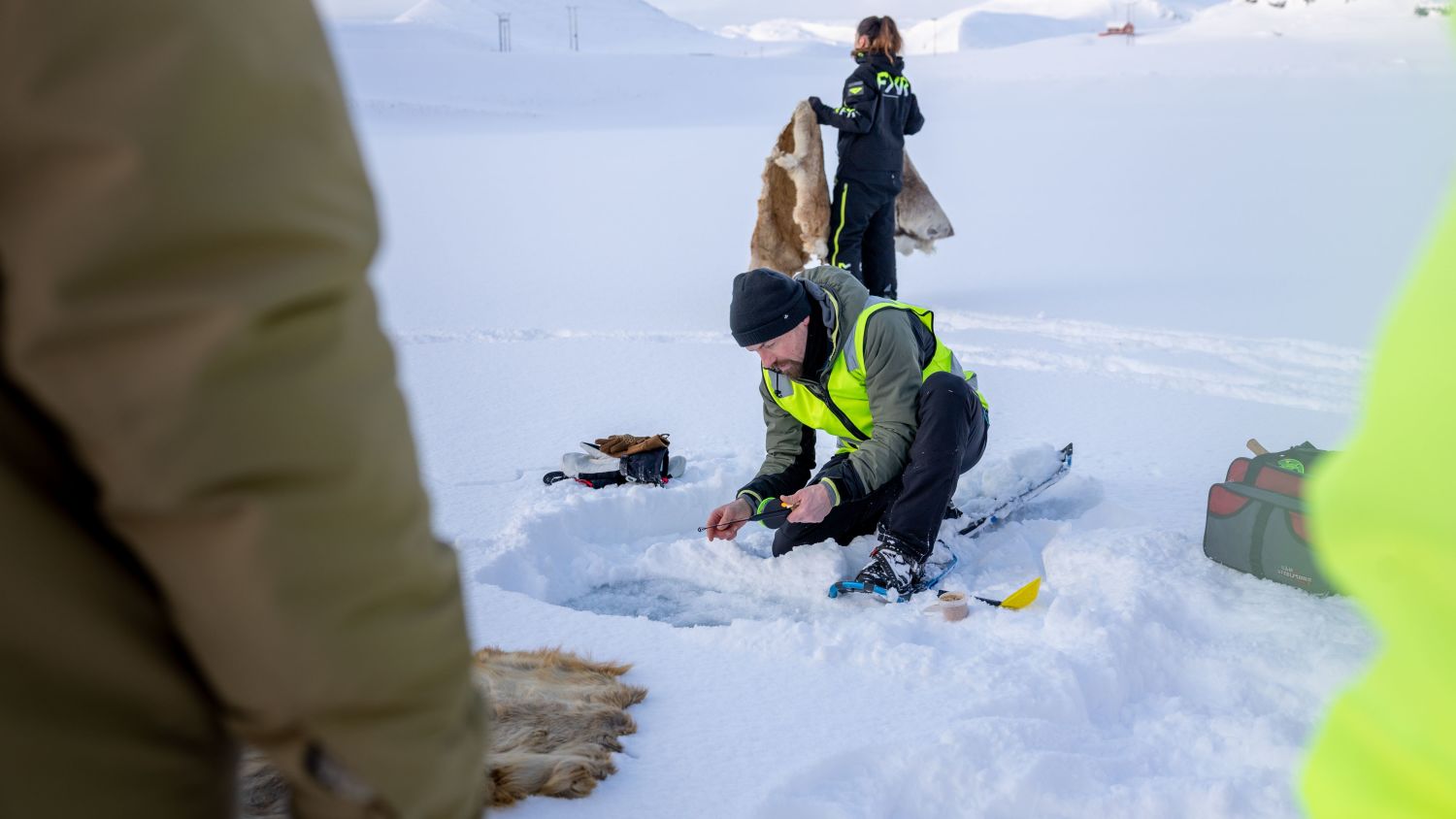 Guide preparing hole for ice fishing