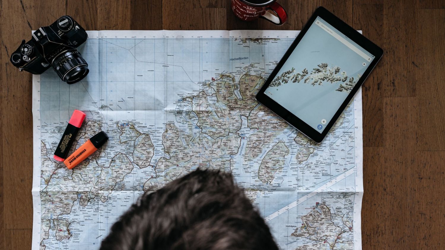 Person looking at a map of the norwegian coast, photo: Simon Migaj, Unsplash